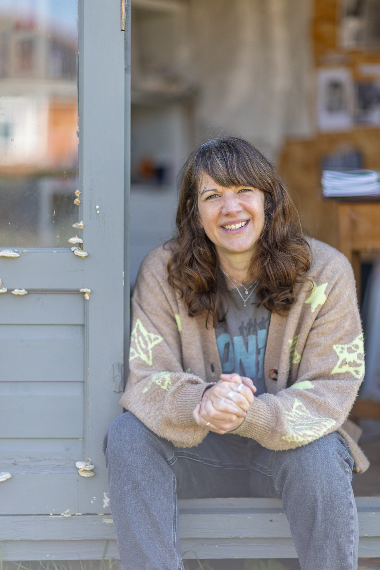 A photo of Sara Truckel sat outside her art studio